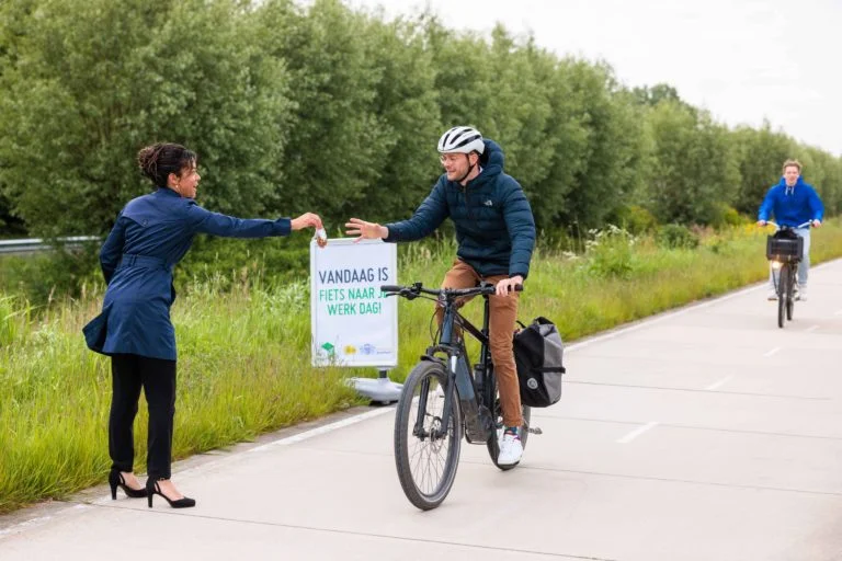 Een Fietser Ontvangt Een Zakje Notenmix Uit Handen Van Gedeputeerde Melissa Van Hoorn. Fotograaf Jan Buwalda (002)